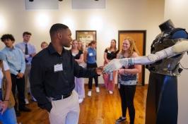 Student shaking hands with robotic prosthetic arm